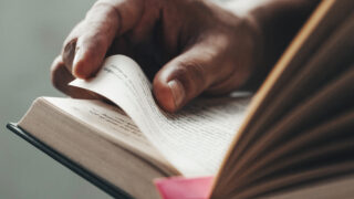 Close up man hands.Young man opening and reading a book,